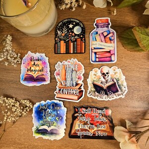 May include: Set of 7 colorful book-themed stickers with various quotes about reading. The stickers feature illustrations of books, a jar of books, a skeleton reading a book, and flowers.