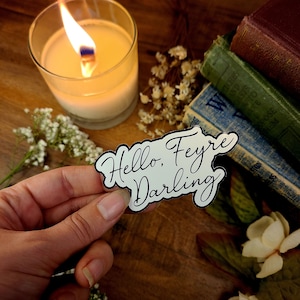 K&ouml;nnte beinhalten: Wei&szlig;er Aufkleber mit schwarzer Aufschrift "Hello, Feyre Darling".