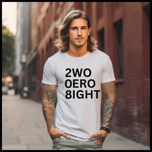 May include: A white t-shirt with black text that reads "2WO OERO 8IGHT".