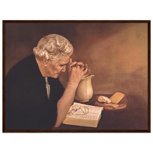 Op de afbeelding: Een schilderij van een oudere vrouw met grijs haar die bidt met haar handen gevouwen. Ze draagt een zwarte jurk en zit aan een tafel met een kan, brood en een open boek.