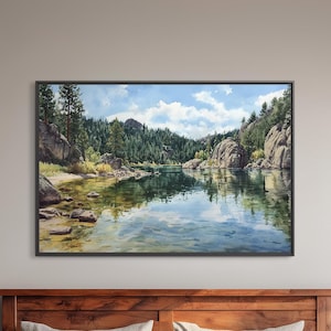 May include: A framed landscape painting depicts a serene lake scene with reflections of trees and rocks. The artwork, with a black frame, hangs above a wooden bed frame, complemented by matching nightstands and lamps.