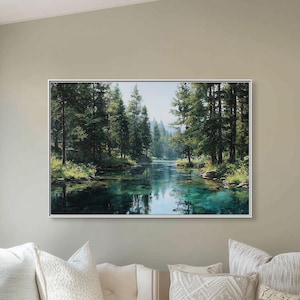 May include: A framed landscape painting of a serene river scene with lush green trees and clear blue water hangs above a white cushioned bench. The room features large windows, neutral-toned walls, and decorative pillows.