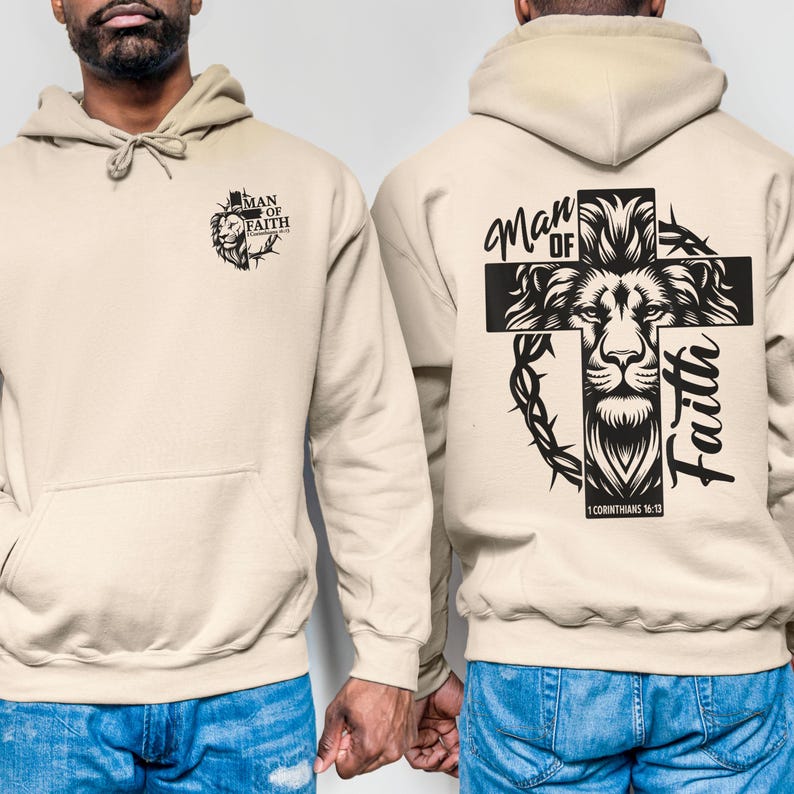 May include: Beige hoodie with a front kangaroo pocket and drawstring hood. The front features a black graphic of a lion and the text "MAN OF FAITH". The back displays a large cross design with a lion, the words "Man of Faith", and the Bible verse 1 Corinthians 16:13.