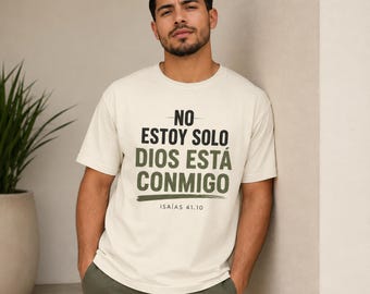 May include: A cream-colored short-sleeve t-shirt featuring the black and olive green text "NO ESTOY SOLO DIOS ESTÁ CONMIGO" and "ISAÍAS 41:10" printed on the front. The shirt has a crew neckline and a relaxed fit, with a brushstroke graphic.