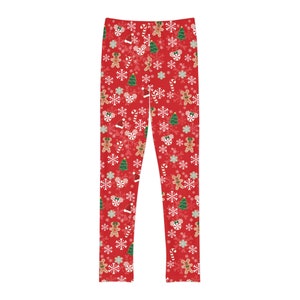 以下が含まれることがあります： クリスマスをテーマにしたパターンが施された赤いレギンス。ジンジャーブレッドマン、キャンディーケーン、雪片、クリスマスツリーが描かれています。