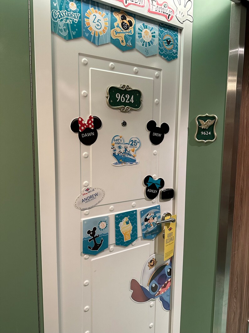 Puede incluir: Una puerta blanca con marco verde decorada con pegatinas y imanes con tem&aacute;tica de Disney. La puerta tiene una placa de n&uacute;mero que dice "9624". Hay varias pegatinas con nombres como "Dawn", "Drew", "Ashley" y "Andrew". Tambi&eacute;n hay pegatinas con im&aacute;genes de Mickey Mouse, Stitch y un crucero.