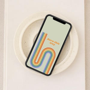Puede incluir: Un teléfono inteligente que muestra un fondo de pantalla con un diseño de arcoíris y el texto "Born this way".