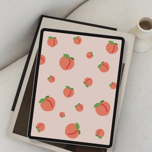 May include: A digital tablet with a peach pattern wallpaper. The peaches are pink with green leaves and are arranged in a repeating pattern on a light pink background.