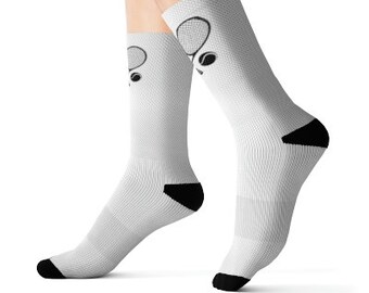 May include: White crew socks with a black tennis racket and ball design. The socks have a black heel and toe.