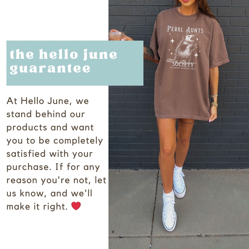 May include: A brown oversized t-shirt with the text "Feral Aunts Society" and a graphic of a possum. The t-shirt is worn by a person standing on a sidewalk.