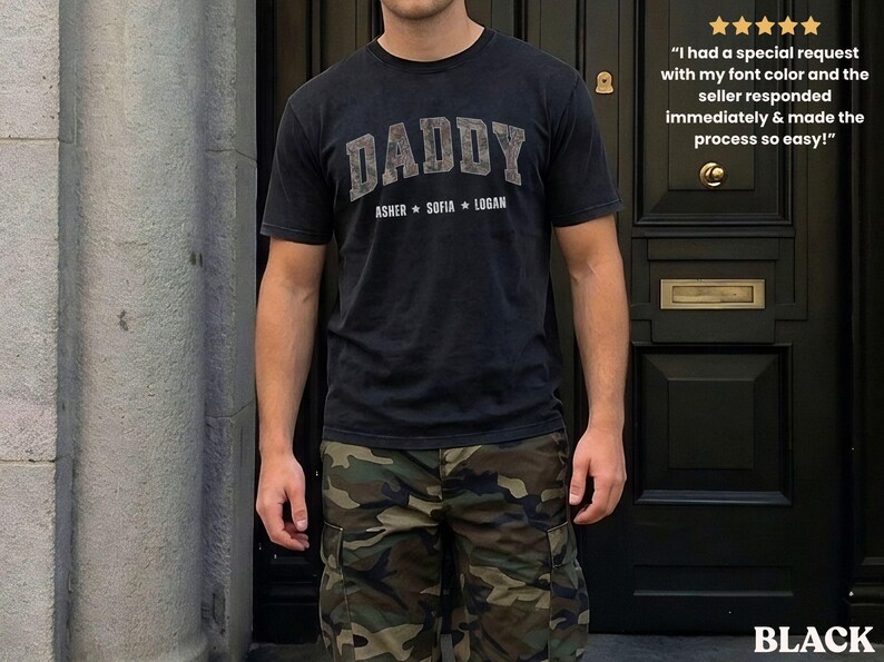 K&ouml;nnte beinhalten: Schwarzes T-Shirt mit dem Wort "DADDY" in einer verblassten Schriftart und den Namen "ASHER SOFIA LOGAN" darunter. Die Person tr&auml;gt eine Camouflage-Cargohose. Das Wort "BLACK" steht unten.