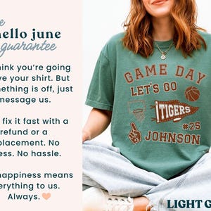 May include: Light green t-shirt with a brown graphic that says "Game Day, Let's Go Tigers #25 Johnson" and a basketball. The shirt also has the text "hello june guarantee".