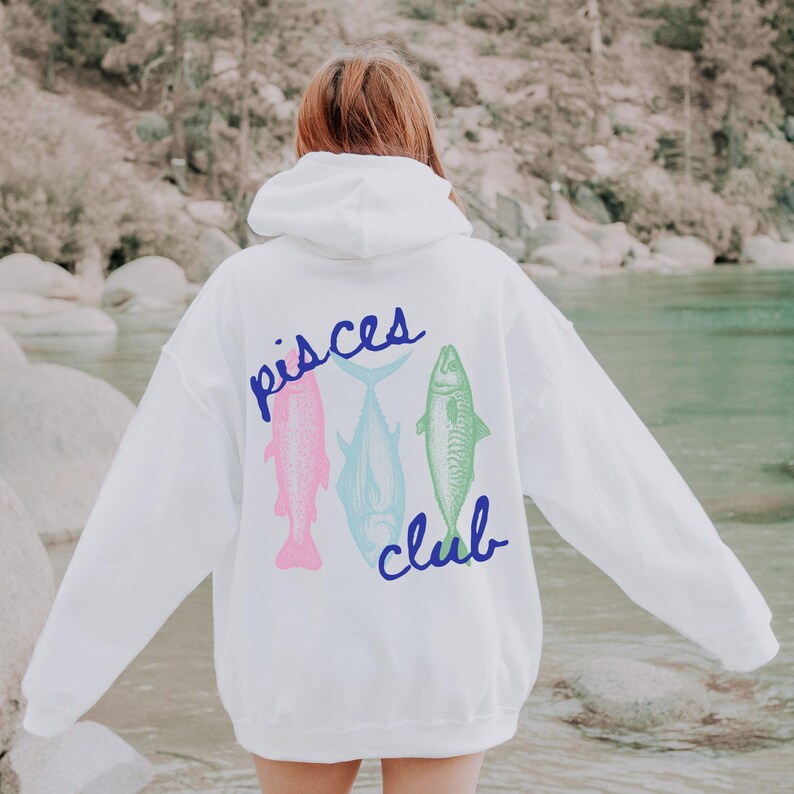 May include: White hoodie with a blue "Pisces Club" graphic featuring three fish in pink, blue, and green.