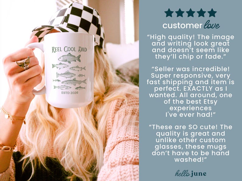 May include: White ceramic mug featuring the text "Reel Cool Dad" and green fish illustrations. The mug also has the text "ESTD 2026". A person is holding the mug, wearing a black and white checkered hat.