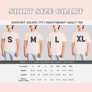 May include: A size chart for a heavyweight adult tee shirt in Comfort Colors 1717. The chart shows measurements in inches for width, length, sleeve, and center back for sizes S through 4XL.