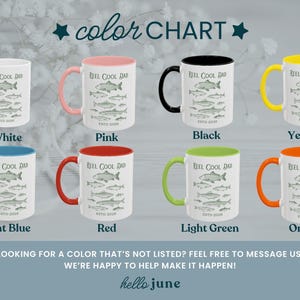 May include: A colour chart shows eight ceramic mugs with the text "REEL COOL DAD" and a fish graphic. The mugs come in white, pink, black, yellow, light blue, red, light green, and orange. The text "ESTD 2026" is also visible.