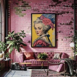 May include: A framed pop art print featuring a woman with powdered hair and a pink and blue bow. The artwork is set against a yellow background with the French text "laissez-les manger du gâteau". The print hangs on a pink brick wall above a pink sofa.