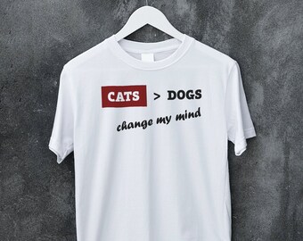 May include: White t-shirt with the text "CATS > DOGS change my mind" printed on it. The text "CATS > DOGS" is in a red box.
