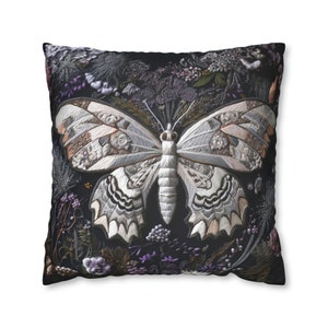 May include: A black pillow with a white embroidered butterfly surrounded by purple and green flowers.
