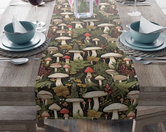 May include: A table runner with a mushroom and foliage pattern. The runner is dark green with red, white, and brown mushrooms. The runner is on a wooden table with place settings.