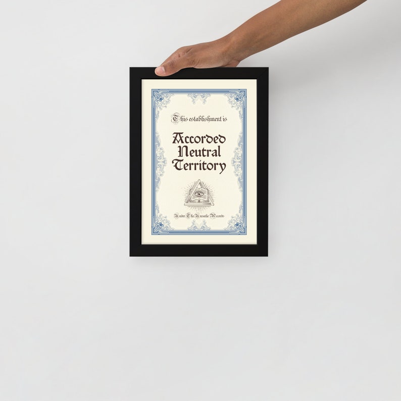 Op de afbeelding: Een ingelijst afdruk met een blauwe en witte rand en een witte achtergrond. De tekst luidt "Deze inrichting is aangewezen als neutraal gebied" met een symbool van een alziend oog onder de tekst.