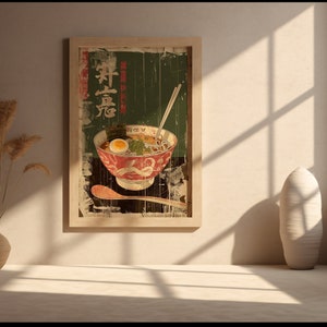 May include: A vintage-style poster featuring a bowl of ramen with an egg, seaweed, and other toppings. The poster has a faded, distressed look and is framed in a wooden frame.