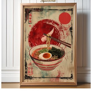 May include: A vintage-style poster featuring a bowl of ramen noodles with a red sun and Japanese characters in the background. The ramen bowl is red and white striped with a soft-boiled egg, green onions, and seaweed. The chopsticks are holding a strand of noodles.