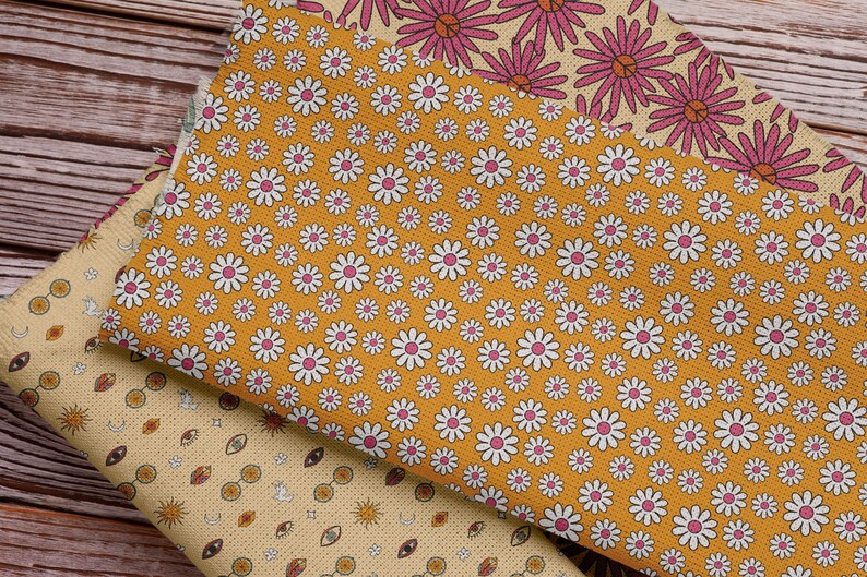 Pode incluir: Tr&ecirc;s amostras de tecido com padr&otilde;es diferentes. A amostra superior tem um padr&atilde;o floral rosa e branco. A amostra do meio tem um fundo amarelo com margaridas brancas. A amostra inferior tem um fundo amarelo com um padr&atilde;o repetitivo de olhos, s&oacute;is e luas.