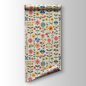 Pu&ograve; includere: Un rotolo di carta da parati bianca con un motivo ripetitivo di fiori colorati. I fiori sono in tonalit&agrave; di rosa, giallo, blu e verde. La carta da parati &egrave; arrotolata e la fine &egrave; ripiegata.