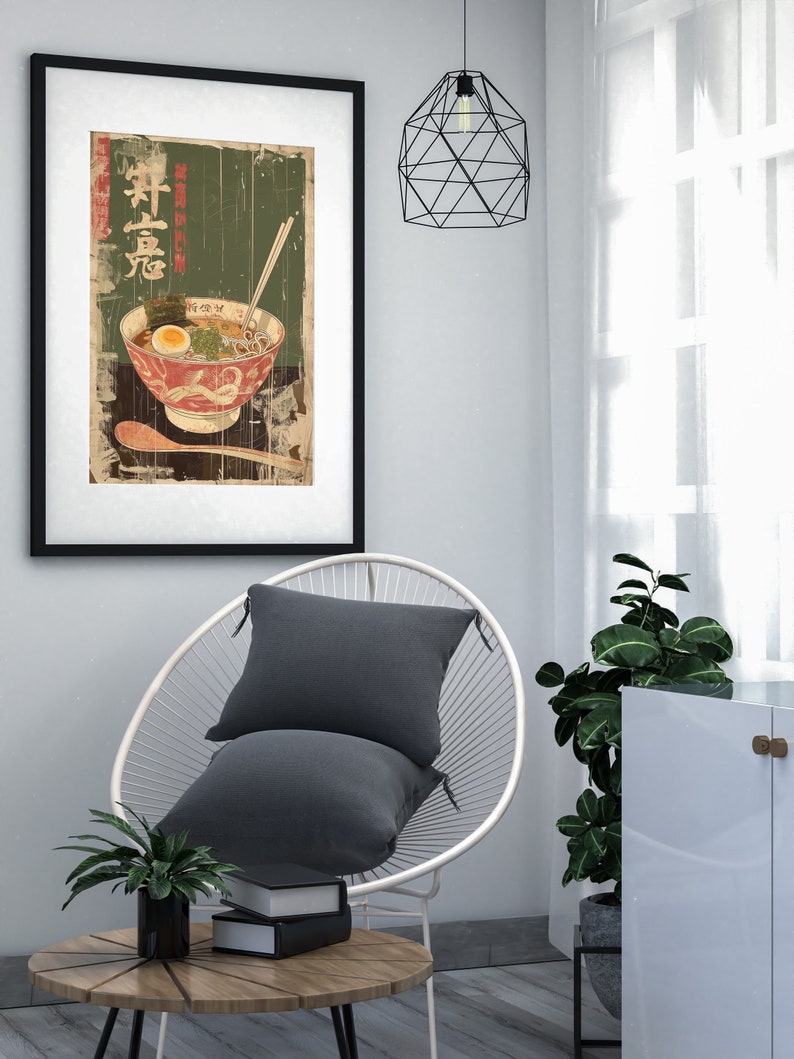 May include: A framed print of a vintage Japanese poster featuring a bowl of ramen noodles with a green background and the text "Ramen" in Japanese characters.