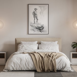 May include: A bedroom interior with a white bed, a tan blanket, two white nightstands, and two hanging glass globe lights. A black framed print of a man standing on a rock is hanging on the wall above the bed.