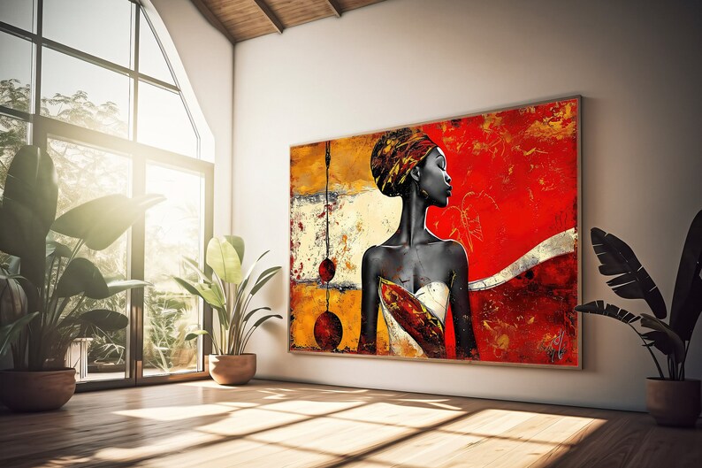 May include: Abstract painting of a woman with a red, yellow, and gold background. The woman is wearing a head wrap and a white dress. The painting is framed and hanging on a white wall.