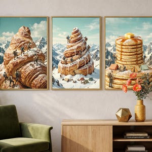 Può includere: Tre stampe artistiche incorniciate raffigurano scene surreali di figure in miniatura che scalano pasticcini giganti in un ambiente montuoso innevato. Un croissant, un rotolo alla cannella e una pila di pancake con burro e sciroppo.