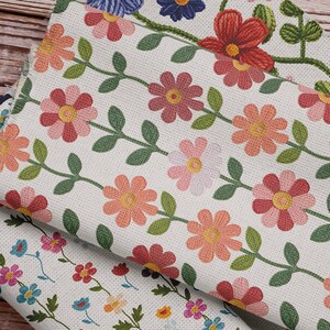 Pu&ograve; includere: Tre pezzi di tessuto con motivi di ricamo floreale. Il tessuto superiore ha uno sfondo bianco con fiori rosa e gialli e foglie verdi. Il tessuto intermedio ha uno sfondo bianco con fiori rossi e gialli e foglie verdi. Il tessuto inferiore ha uno sfondo bianco con fiori blu, rosa, gialli e rossi e foglie verdi.