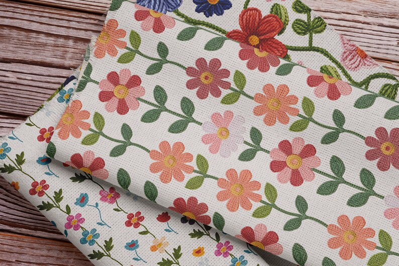 Pu&ograve; includere: Tre pezzi di tessuto con motivi di ricamo floreale. Il tessuto superiore ha uno sfondo bianco con fiori rosa e gialli e foglie verdi. Il tessuto intermedio ha uno sfondo bianco con fiori rossi e gialli e foglie verdi. Il tessuto inferiore ha uno sfondo bianco con fiori blu, rosa, gialli e rossi e foglie verdi.