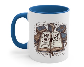Puede incluir: Taza de cerámica blanca con borde y asa azules. La taza presenta una ilustración de dibujos animados de un libro abierto con el texto "ME LIKE BOOKS!" y una pila de libros a su alrededor.