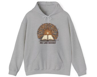 Puede incluir: Una sudadera con capucha gris claro con un gráfico frontal de un libro abierto que irradia rayos de sol y estrellas. El texto "ME LIKE BOOKS!" está debajo del libro. La sudadera tiene una capucha con cordón y un bolsillo delantero.
