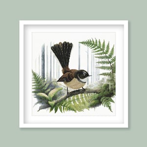 May include: A brown and black bird with a long tail sits on a branch in a forest setting. The bird is surrounded by green ferns and leaves.