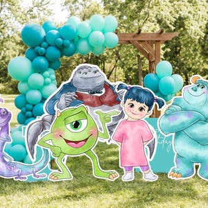 Könnte beinhalten: Eine Partyszene mit Pappfiguren von Charakteren aus dem Film Die Monster AG, darunter Mike Glotzkowski, Sulley und Boo. Ein Ballonbogen in Blau- und Grüntönen und ein Schild mit der Aufschrift "Happy Birthday" vervollständigen die festliche Umgebung im Freien.