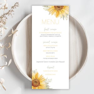Może przedstawiać: Biała karta menu z motywem słonecznika. Menu zawiera dania: Sałatka truskawkowa, Grillowany kurczak, Medaliony wołowe, Mahi Mahi, Ciasto czekoladowe i Sernik. Menu znajduje się na białym talerzu.