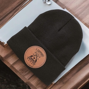 May include: Black beanie with a brown leather patch that says "I Support Armed Americans" with a crossed rifle design.