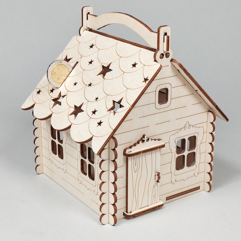 Pode incluir: Uma casa de bonecas de madeira com uma al&ccedil;a, com um telhado ondulado com recortes de estrelas. A casa tem uma porta, janelas e acabamentos decorativos. A cor natural da madeira &eacute; acentuada por bordas marrons mais escuras.