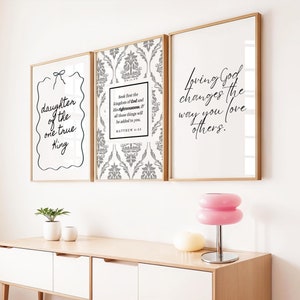 Puede incluir: Tres impresiones enmarcadas con citas inspiradoras. La impresión de la izquierda tiene un fondo blanco con texto negro que dice "daughter of the one true King". La impresión del medio tiene un fondo estampado en gris y blanco con texto negro que dice "Seek first the kingdom of God and His righteousness, and all those things will be added to you. Matthew 6:33". La impresión de la derecha tiene un fondo blanco con texto negro que dice "Loving God changes the way you love others."