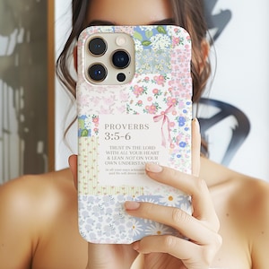 May include: A floral patterned phone case with a patchwork design. The case features a variety of pastel colors and small flower patterns. Text on the case reads "PROVERBS 3:5-6" and a religious quote.