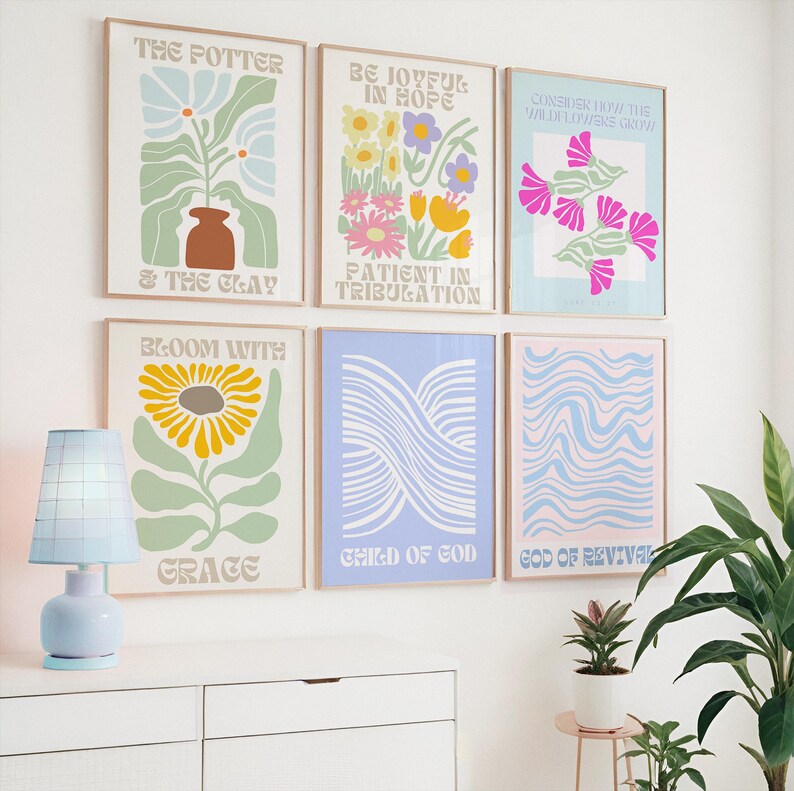 May include: A collection of six framed art prints with inspirational quotes and floral designs. The prints feature pastel colors, including blue, pink, yellow, and green. Text on the prints includes phrases like "The Potter & The Clay" and "Bloom With Grace."