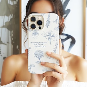 Op de afbeelding: Witte telefoonhoesje met een bloemenpatroon en een blauwe quote uit Jeremia 29:11, "Want Ik weet welke plannen Ik voor jullie heb", spreekt de HEERE.