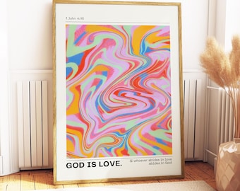 May include: A framed art print featuring a vibrant, swirled abstract design in pink, blue, orange, and green. The text "GOD IS LOVE" is at the bottom, with "1 John 4:16" at the top. The print is in a gold frame.