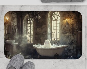 Puede incluir: Una alfombrilla de baño rectangular con una escena impresa de un fantasma blanco sentado en una bañera con patas llena de burbujas, en un baño de piedra con ventanas arqueadas, junto a un par de zapatillas grises y una toalla gris.