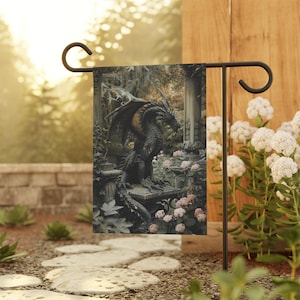 May include: A black dragon statue in a garden setting. The dragon is perched on a stone pedestal with flowers and greenery surrounding it. The statue is detailed and realistic, with scales, wings, and claws.