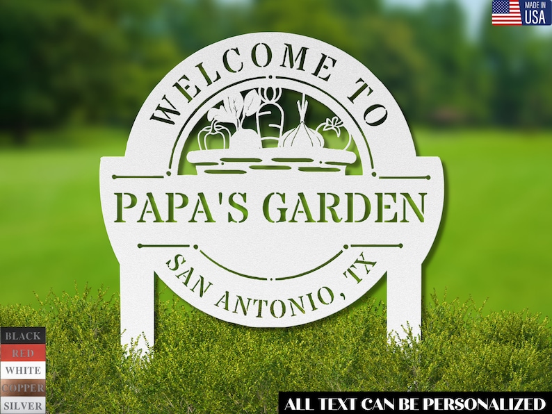K&ouml;nnte beinhalten: Wei&szlig;es Garten Schild aus Metall mit einem Korb voller Gem&uuml;se und dem Text "Willkommen im Garten von Papa San Antonio, TX". Der Text kann personalisiert werden.